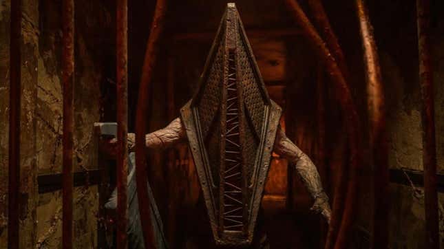 Pyramid Head tenant une grande épée derrière des barreaux courbés