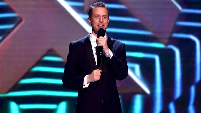 Geoff Keighley monte sur scène avec un micro